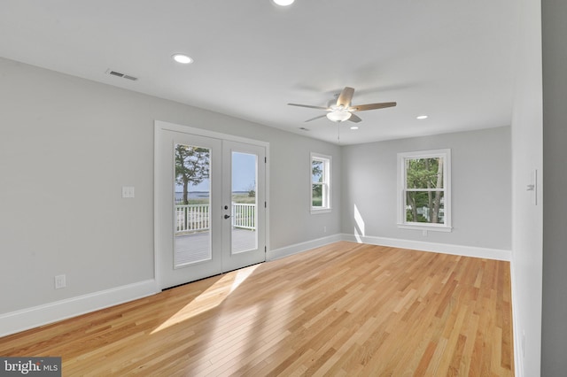 spare room featuring light hardwood / wood-style flooring, ceiling fan, and french doors