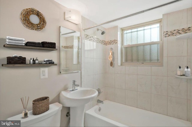 bathroom with tiled shower / bath combo and toilet