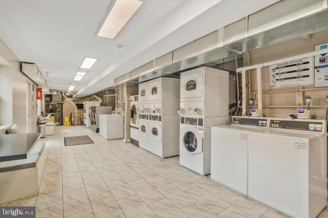 clothes washing area with separate washer and dryer, light tile flooring, and stacked washer / dryer