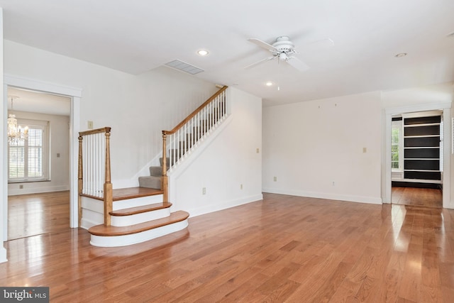 interior space with light hardwood / wood-style floors and ceiling fan with notable chandelier