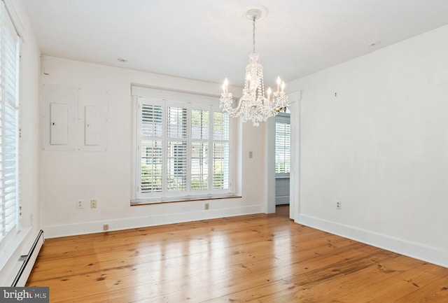 empty room with an inviting chandelier, light wood-type flooring, and baseboard heating