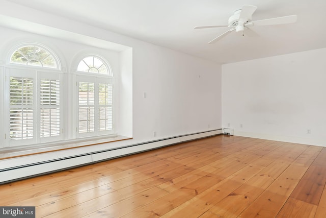 unfurnished room featuring ceiling fan, a baseboard heating unit, and light hardwood / wood-style floors