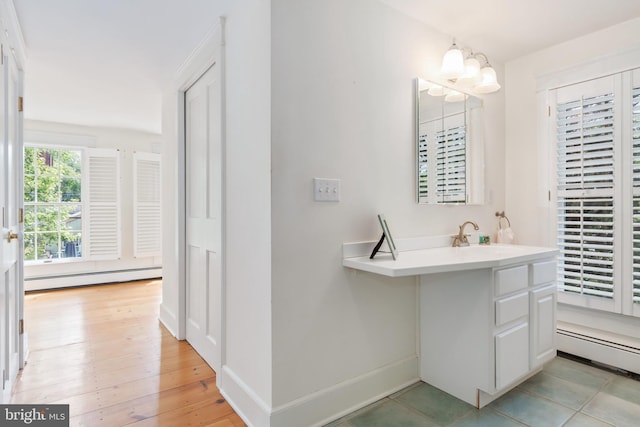 bathroom featuring vanity with extensive cabinet space, tile flooring, and a baseboard radiator