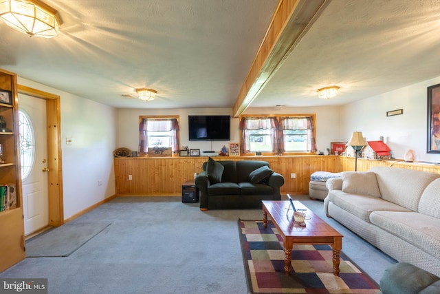 living room with light carpet, beamed ceiling, and a textured ceiling