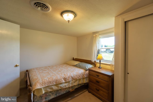 bedroom featuring a textured ceiling and carpet