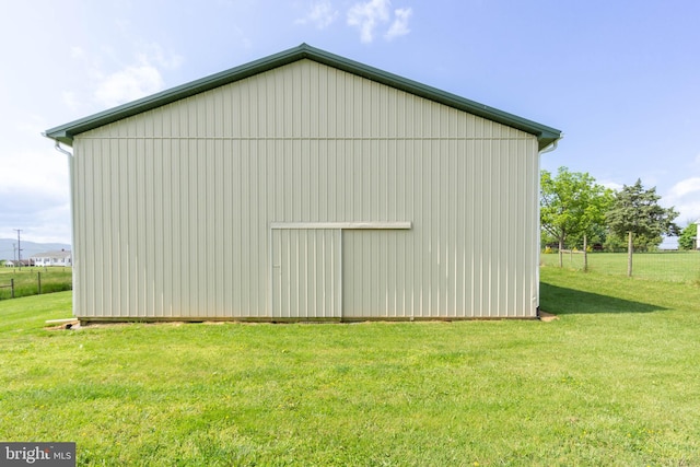 view of side of property with a yard and an outbuilding