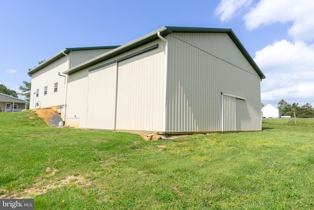 view of side of home featuring an outbuilding and a yard