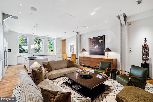 living room with sink and light hardwood / wood-style flooring