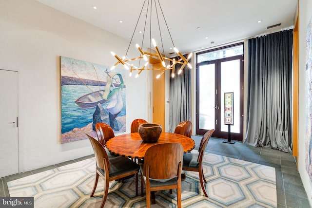 dining area with dark tile flooring and a chandelier