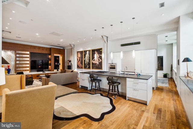 dining space with sink and light wood-type flooring