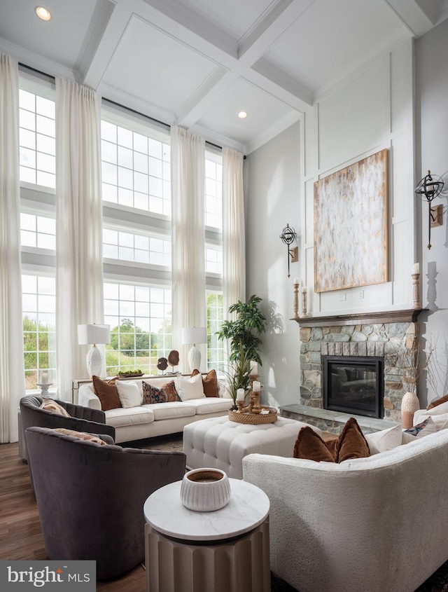 living room with a towering ceiling, a fireplace, beamed ceiling, dark hardwood / wood-style flooring, and coffered ceiling