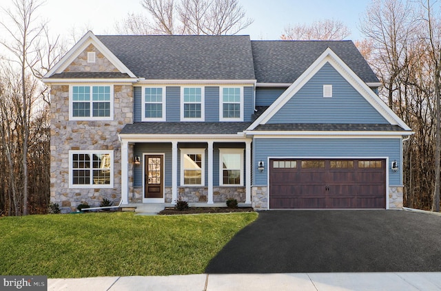 craftsman house featuring a garage, covered porch, and a front lawn