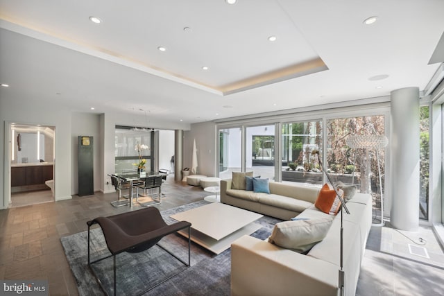 living room featuring a tray ceiling and plenty of natural light