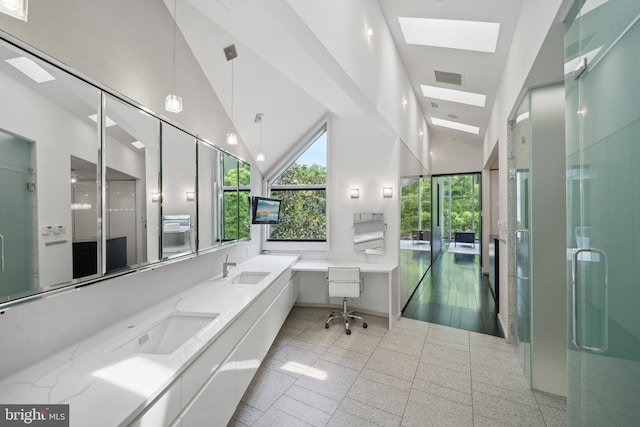 bathroom with a skylight, tile patterned floors, an enclosed shower, vanity, and high vaulted ceiling