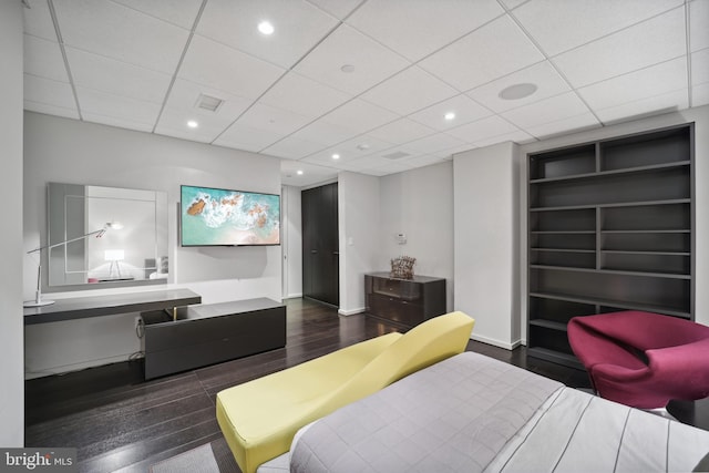 bedroom featuring a paneled ceiling and dark hardwood / wood-style floors