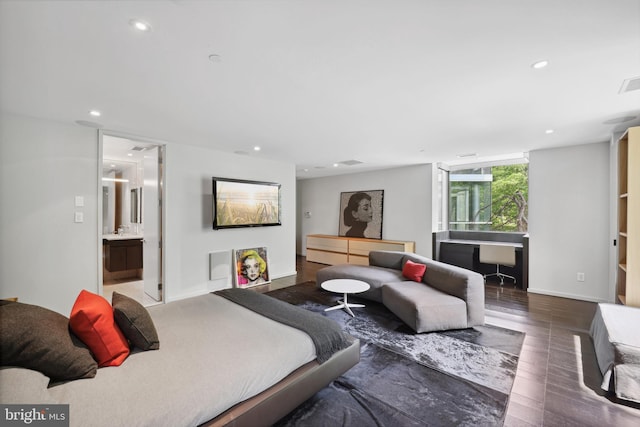 bedroom with connected bathroom and hardwood / wood-style floors