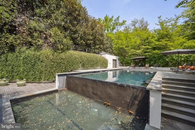 view of swimming pool with a deck and an outdoor structure