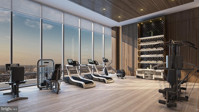 gym featuring light wood-type flooring, wooden ceiling, and floor to ceiling windows