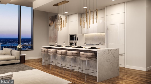 bar featuring decorative light fixtures, hardwood / wood-style flooring, backsplash, and white cabinets