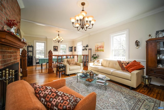 living room with a brick fireplace, a notable chandelier, plenty of natural light, and dark hardwood / wood-style floors