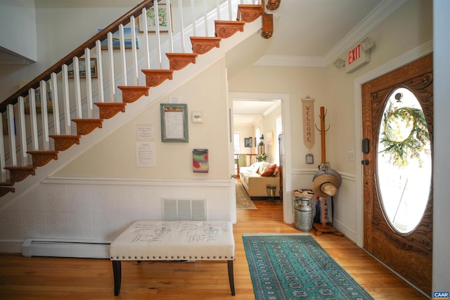 entryway featuring ornamental molding, a baseboard heating unit, and light hardwood / wood-style flooring