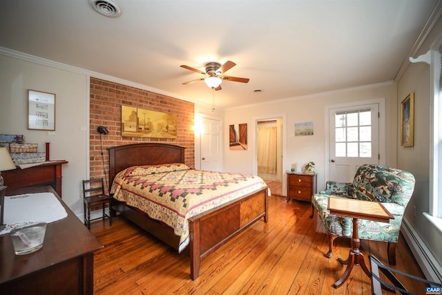 bedroom with dark hardwood / wood-style floors, a brick fireplace, ceiling fan, crown molding, and a baseboard radiator