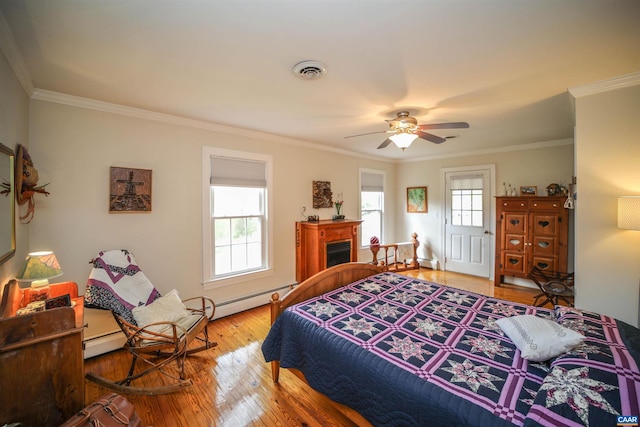 bedroom featuring multiple windows, ornamental molding, ceiling fan, and light hardwood / wood-style flooring