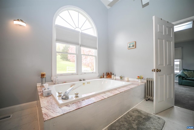 bathroom featuring radiator heating unit, tile floors, high vaulted ceiling, and tiled tub