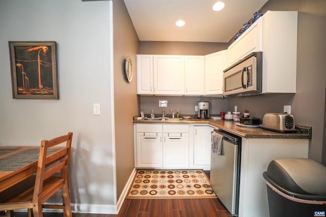 kitchen with white cabinets, dark hardwood / wood-style floors, sink, and stainless steel appliances