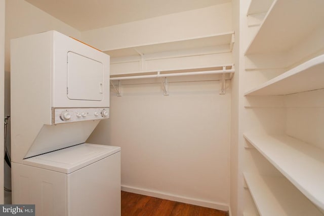 laundry room featuring dark wood-type flooring and stacked washer and dryer