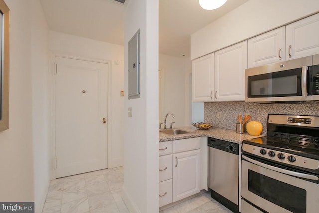 kitchen with stainless steel appliances, white cabinets, light tile floors, and sink