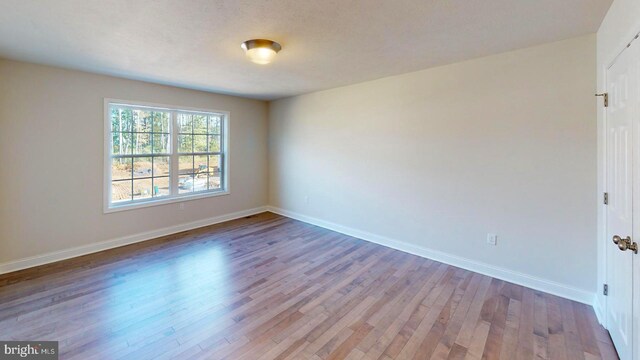empty room featuring baseboards and wood finished floors