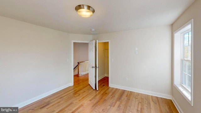 unfurnished room with light wood-style floors and baseboards