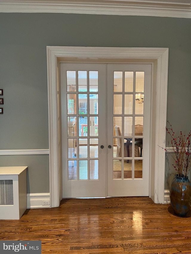 entryway with ornamental molding, dark hardwood / wood-style floors, and french doors