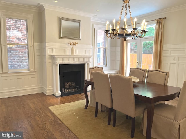 dining room featuring an inviting chandelier, french doors, dark wood-type flooring, and ornamental molding