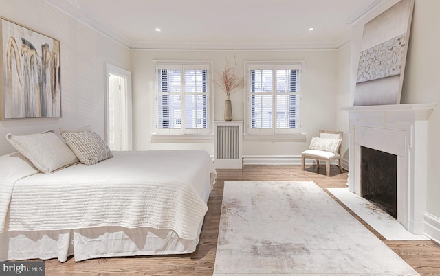 bedroom with dark hardwood / wood-style flooring, a high end fireplace, and ornamental molding