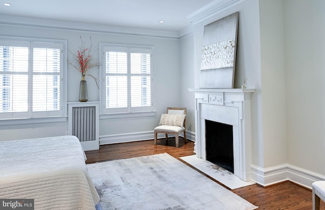 bedroom with ornamental molding and dark hardwood / wood-style floors