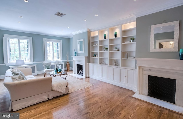 living room featuring crown molding and light hardwood / wood-style flooring