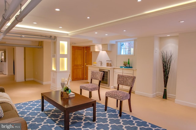 carpeted living room with beverage cooler, sink, and a tray ceiling