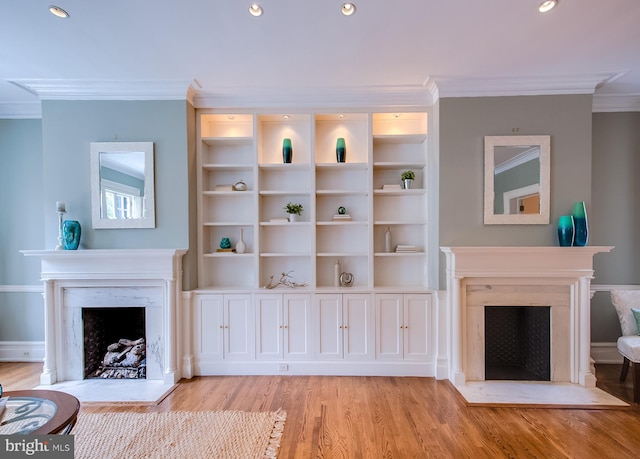 living room featuring a high end fireplace, light hardwood / wood-style flooring, and crown molding