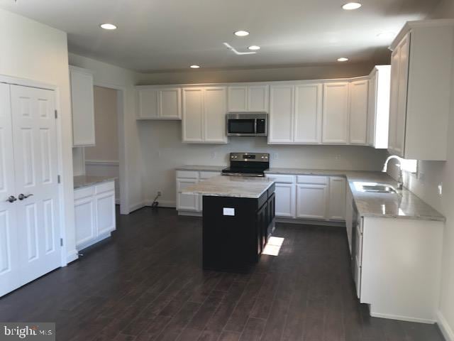 kitchen featuring white cabinetry, range, a kitchen island, and dark wood-type flooring