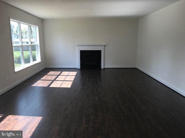 unfurnished living room with dark hardwood / wood-style flooring