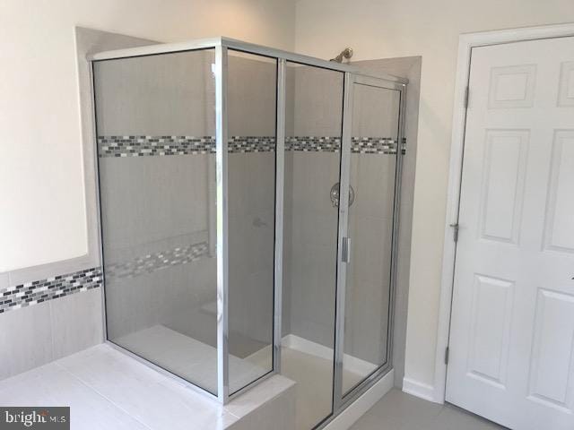 bathroom with walk in shower and tile floors