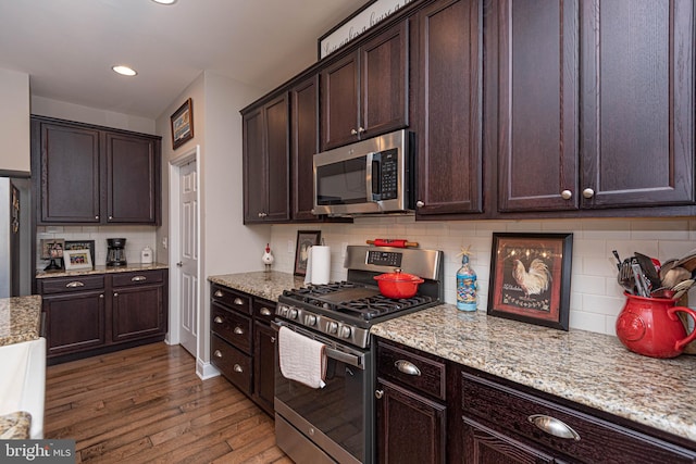 kitchen featuring dark brown cabinets, appliances with stainless steel finishes, and dark wood-type flooring