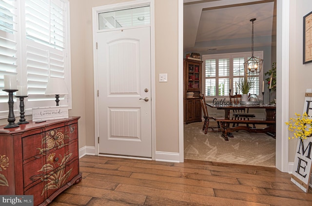 entrance foyer featuring hardwood / wood-style floors and a notable chandelier