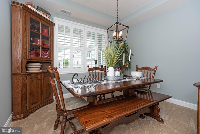 dining room featuring light colored carpet and a chandelier