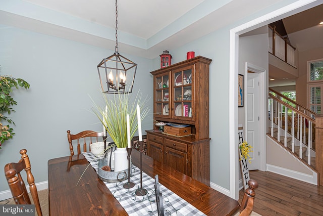 dining area featuring an inviting chandelier and dark wood-type flooring