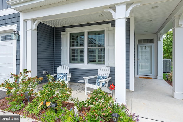 view of exterior entry featuring covered porch, central air condition unit, and a garage