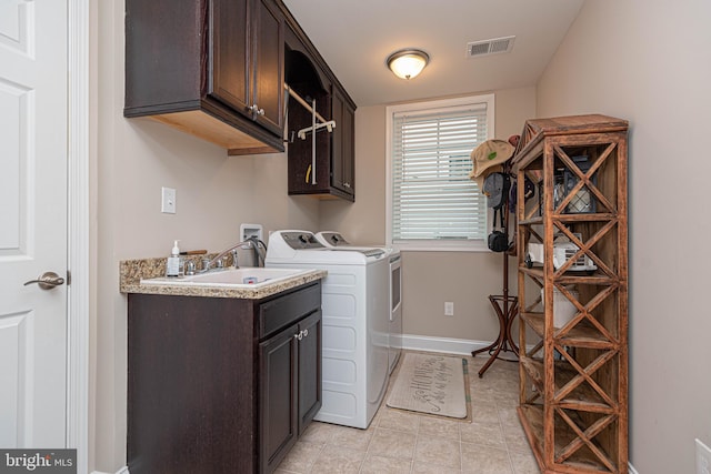 clothes washing area with cabinets, sink, and independent washer and dryer