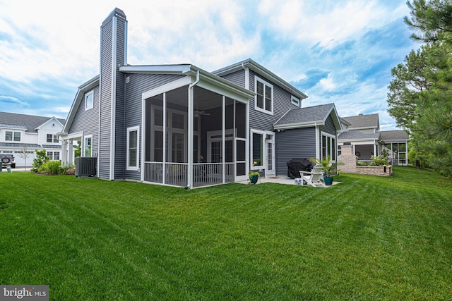 back of property featuring a sunroom, a lawn, a patio area, and central air condition unit